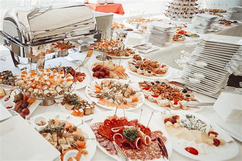 Una mesa de buffet con variedad de platillos para parrillada, incluyendo carnes, ensaladas y salsas
