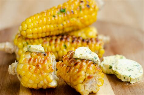Mazorca de maíz untada con mantequilla de ajo y hierbas
