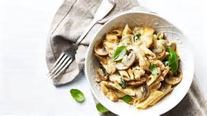 Fotografía apetitosa de fideos cremosos con champiñones y aceitunas.