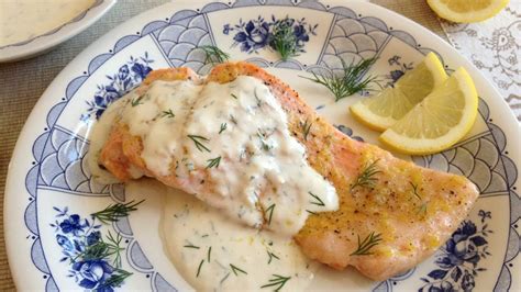 Plato de salmón con salsa cremosa de yogur y eneldo, decorado con limón fresco