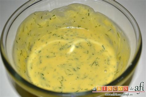 Manos mezclando los ingredientes para la salsa de yogur y eneldo en un bol