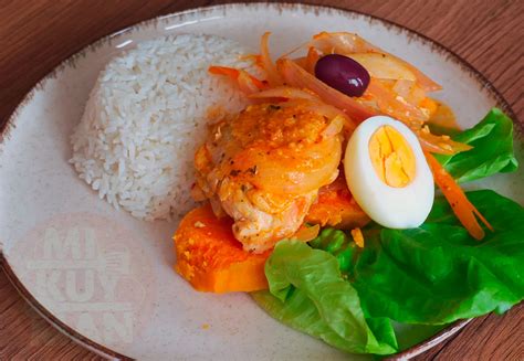 Plato de escabeche de pollo peruano con limón, decorado con huevos, aceitunas y camote