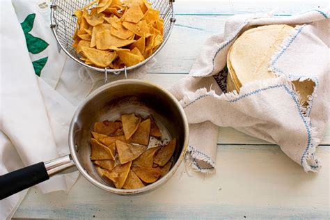 Tortillas de maíz cortadas en triángulos friéndose en aceite