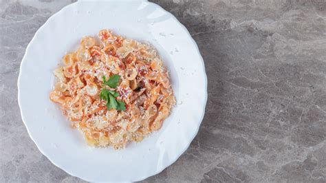 Plato de pasta con una porción moderada al estilo italiano, junto a otros acompañamientos