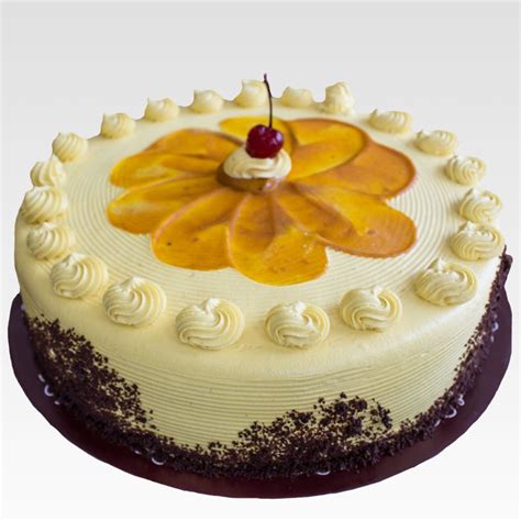 Fotografía profesional de una torta de lúcuma con cobertura cremosa y decoración de rayas laterales