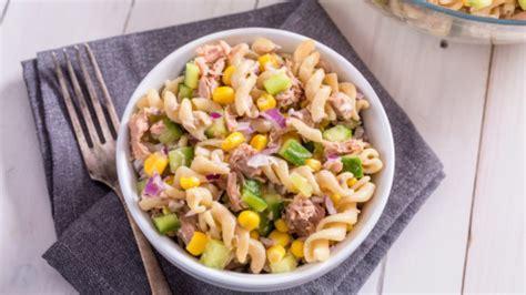Ensalada fresca de pasta con atún y vegetales en un recipiente transparente