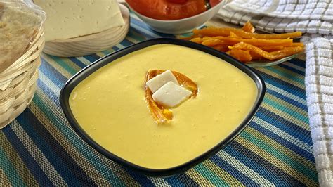 Recipientes pequeños con salsa huancaína, zarza criolla y un vaso de refresco de cebada