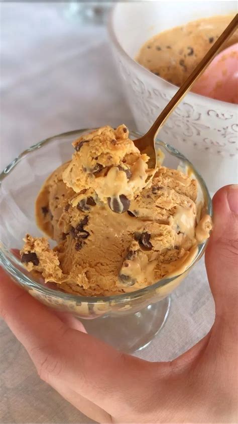 Fotografía profesional de un granizado de yogurt y dulce de leche servido en un vaso de cristal con hilos de caramelo y trozos de nuez