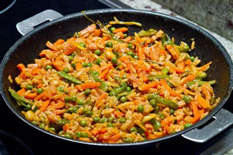Arroz con verduras cocinándose en una paellera