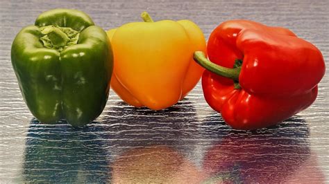 Esquema nutricional comparativo entre pimiento verde, rojo y amarillo resaltando vitaminas y minerales