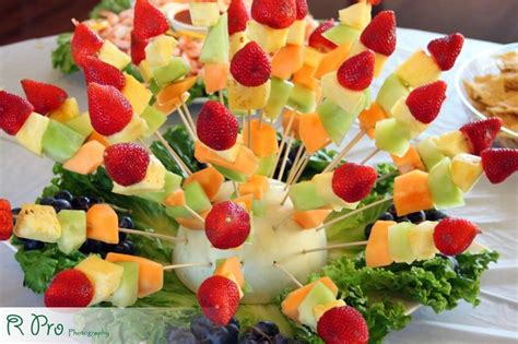 Mesa decorada con brochetas de frutas variadas para un evento