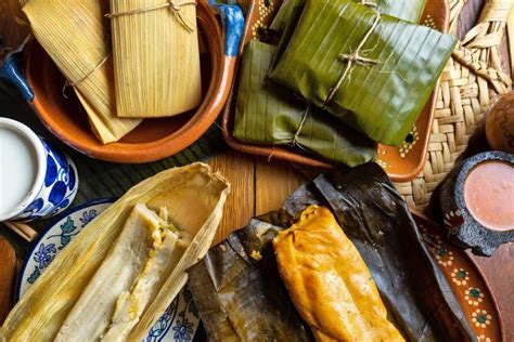 Variedad de tamales envueltos en hojas de maíz y plátano