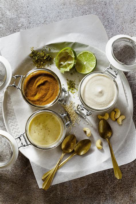 Foto de diferentes tipos de salsas de yogur presentadas en pequeños boles, con ingredientes variados