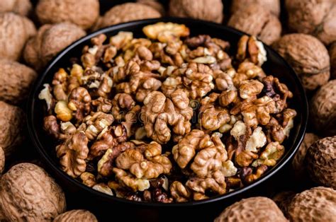 Tazón de nueces enteras y nueces peladas, con un vaso de leche de nuez