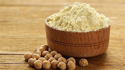 Harina de garbanzo en un cuenco con garbanzos secos al lado