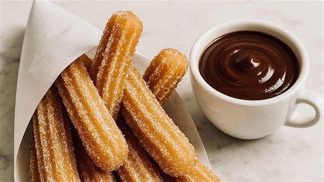 Chocolate caliente con churros y roscón de Reyes en una mesa festiva