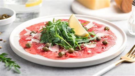 Plato de carpaccio de ternera finamente laminado con aderezos