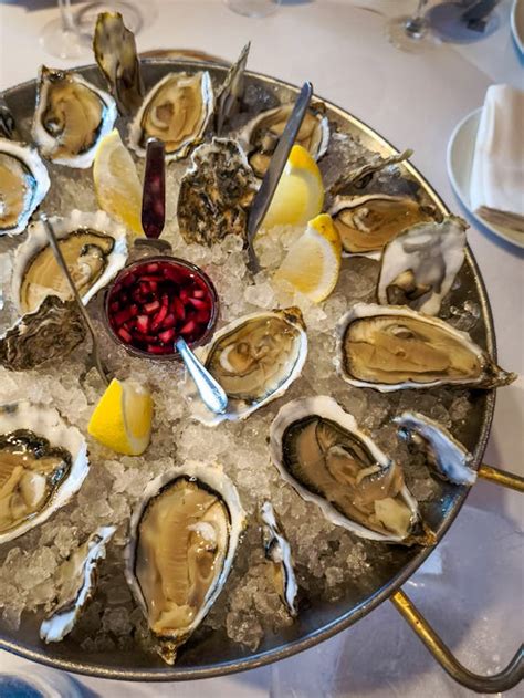 Plato de ostras frescas sobre hielo con rodajas de limón