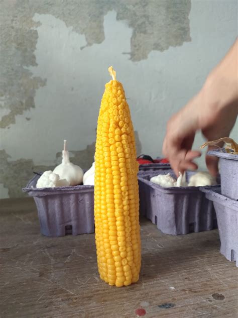 Vela artesanal con forma de choclo o maíz en un ambiente cálido