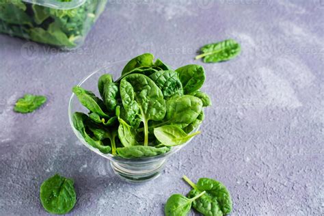 Espinacas frescas almacenadas en un recipiente hermético con papel absorbente en el refrigerador
