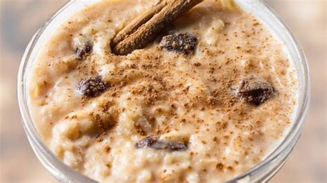 Foto de arroz con leche con pasas y una copa de vino espumoso al lado