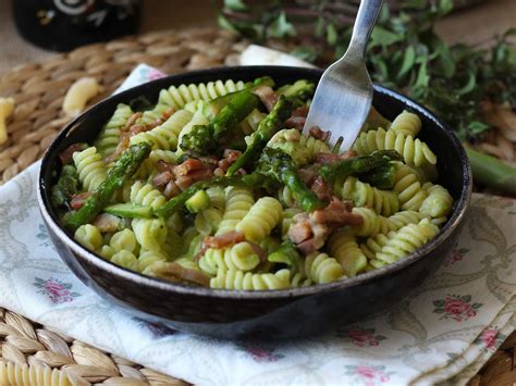 Plato de pasta cremosa con espárragos verdes y tomates cherry