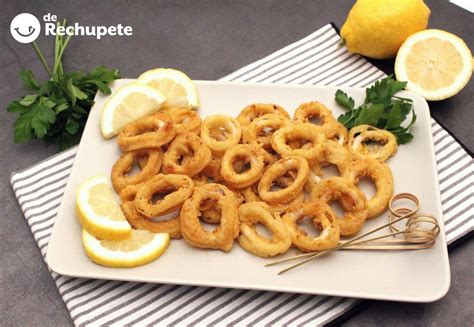 Imagen de una fuente con calamares a la romana dorados, acompañados de rodajas de limón y una pequeña porción de mayonesa.