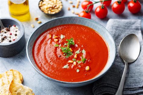 Foto de ingredientes frescos para sopa de tomate: tomates maduros, cebolla, ajo, hierbas
