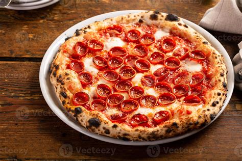 Foto de una pizza napolitana recién horneada con bordes inflados y ligeramente quemados