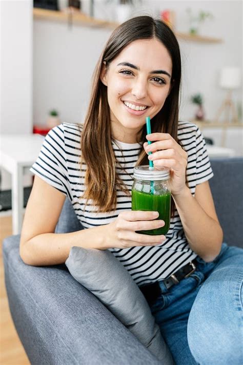 mujer bebiendo jugo verde en un ambiente saludable