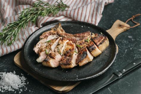 Plato de carne de cerdo servido con una porción de compota de manzana