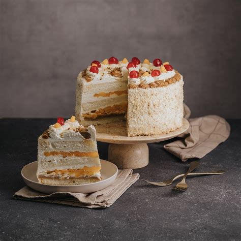 Torta de galletas con manjar y crema chantilly, decorada con frutas