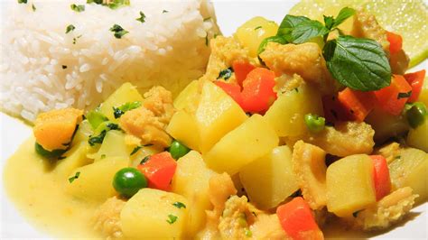 Foto de un plato de Cau Cau de Mariscos terminado, servido con arroz blanco y decorado con hierbas frescas