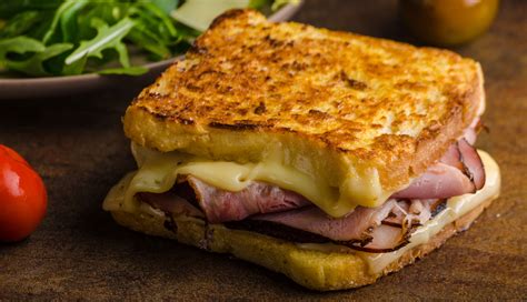 Foto de sándwiches de jamón y queso dorados a la sartén, cortados en triángulos.