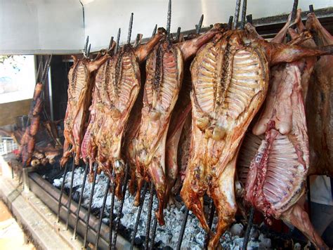 Foto panorámica de un cabrito asado a la leña en un ambiente festivo familiar