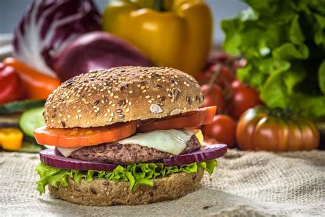 Foto comparativa de pan de hamburguesa integral vs. pan de hamburguesa blanco vs. hojas de acelga como 