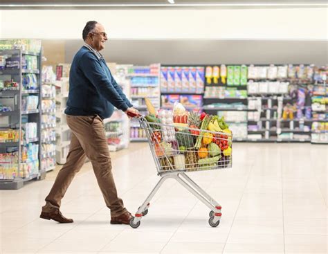 Persona paseando en un supermercado con un carrito y una piña