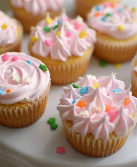 Foto de primer plano de cupcakes decorados con merengue de malvavisco y decoraciones primaverales.