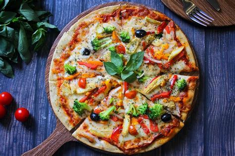 Foto de una pizza vegetariana recién horneada con una variedad de vegetales coloridos y queso derretido