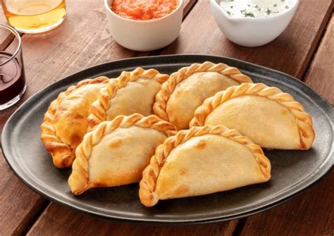 Plato de empanadas argentinas variadas, mostrando los repulgues.