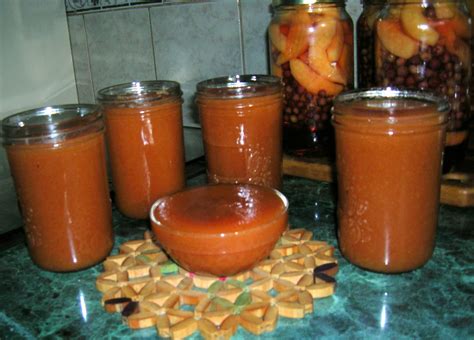 Frascos de conserva de membrillo pasteurizándose en una olla con agua