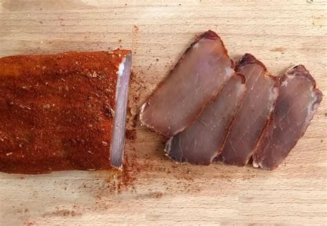 Ilustración comparativa de los procesos de curado de la cecina y el jamón, resaltando las diferencias clave.