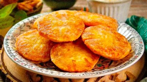 Sopaipillas recién fritas, doradas y crujientes, sobre papel absorbente.