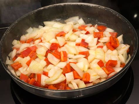Sofrito de cebolla, pimiento y especias cocinándose en una olla