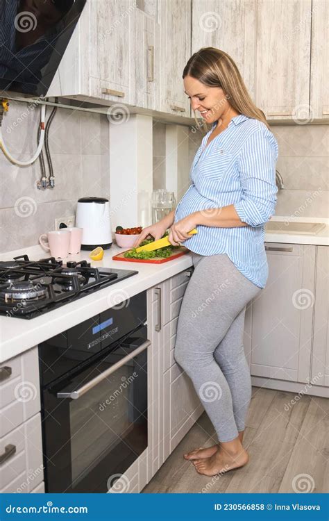Mujer embarazada cocinando de forma segura en la cocina