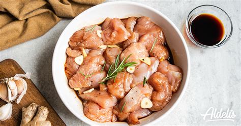 Pollo crudo en tiras marinado con especias en un bol