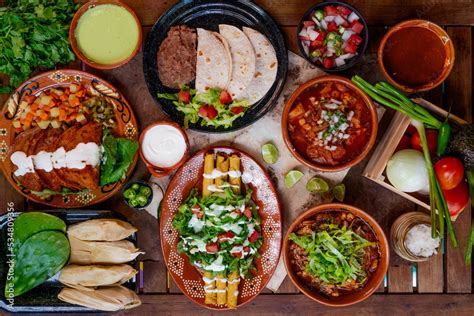 Foto de una mesa mexicana con tacos, totopos y diferentes tipos de salsa, incluyendo salsa verde