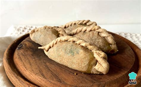 Foto sugerente de empanadas integrales dulces recién horneadas con un espolvoreado de canela o azúcar glass