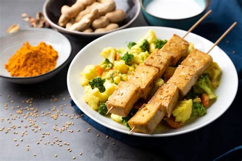 variedad de proteínas vegetales: bloques de tofu, cuencos con legumbres secas y seitán