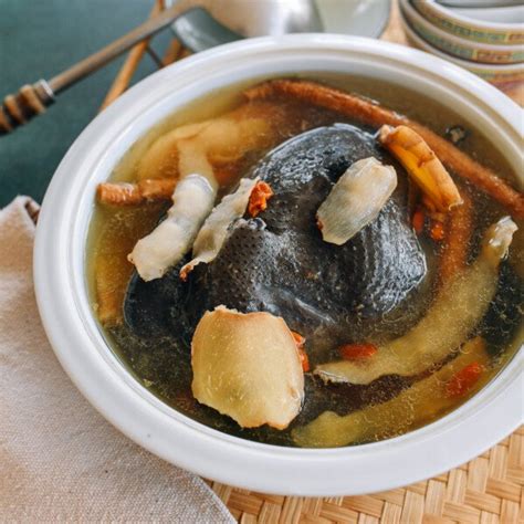 Sopa de pollo sedoso negro con ajo negro servida en un tazón